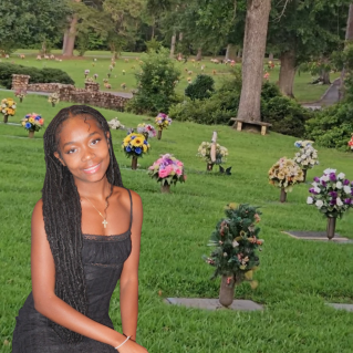 A woman kneeling by a gravestone with a rose, symbolizing remembrance and loss.